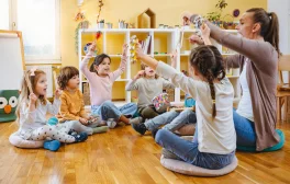 Kinder und Betreuerin in KiTa spielen