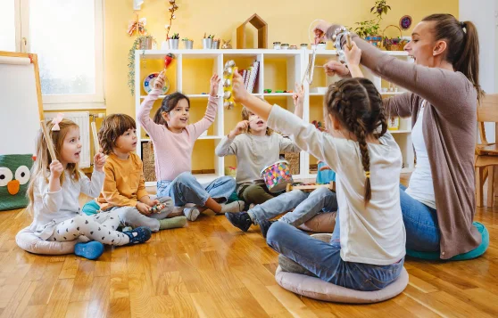 Kinder und Betreuerin in KiTa spielen